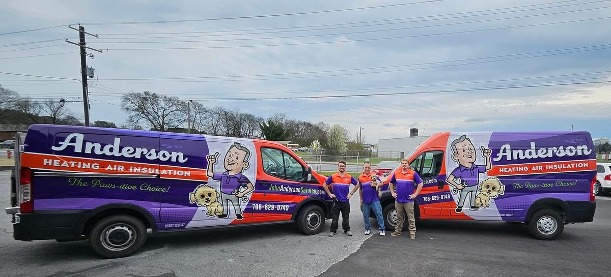 Two John Anderson Service Company branded vans, Heating Air Insulation, with the team