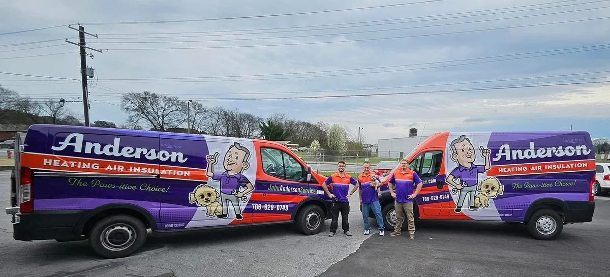 Two John Anderson Service Company branded vans, Heating Air Insulation, with the team