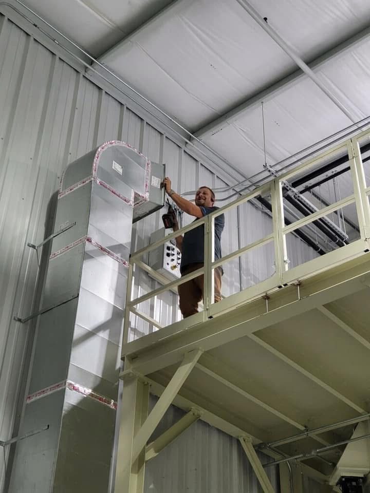 Large commercial packaged rooftop HVAC unit installed beside a metal building