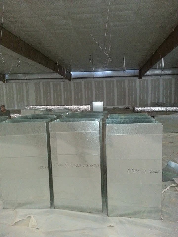 Rows of freshly fabricated sheet-metal duct trunks staged on a commercial jobsite