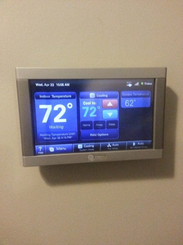 Trane XV20 variable-speed AC condenser newly installed next to a brick-and-siding home