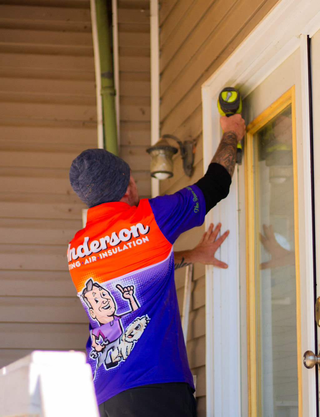 Anderson Heating, Air & Insulation technician drilling a doorway repair on a residential porch — Anderson Heating, Air & Insulation serves Adairsville with HVAC, weatherization, and home-envelope work.