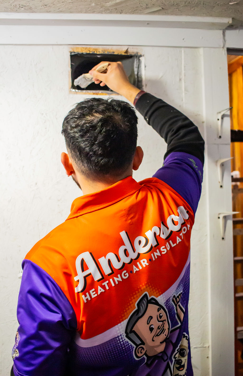 Anderson Heating, Air & Insulation technician applying mastic sealant to a duct opening — duct cleaning without duct sealing leaves the leaks that caused the dust problem in the first place.