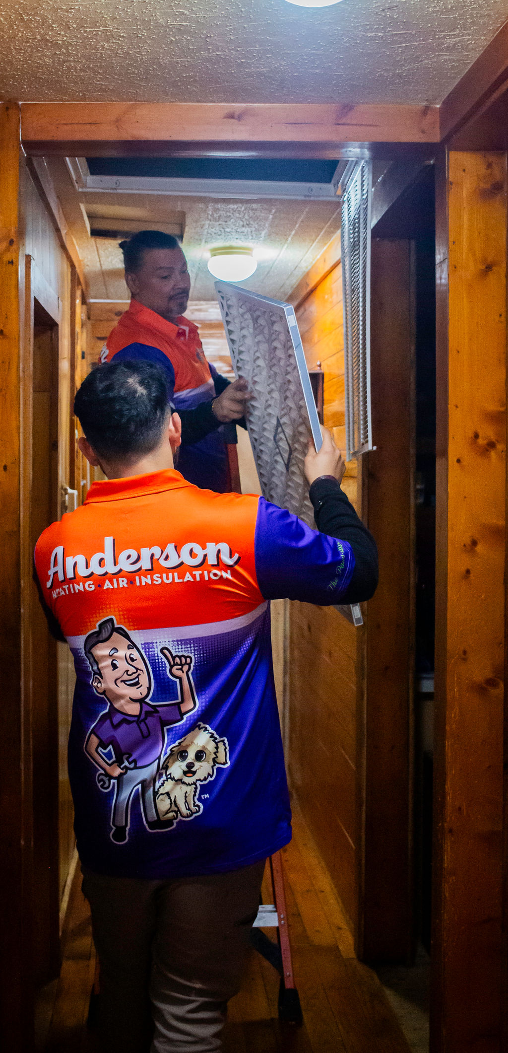Two Anderson techs replacing an HVAC air filter