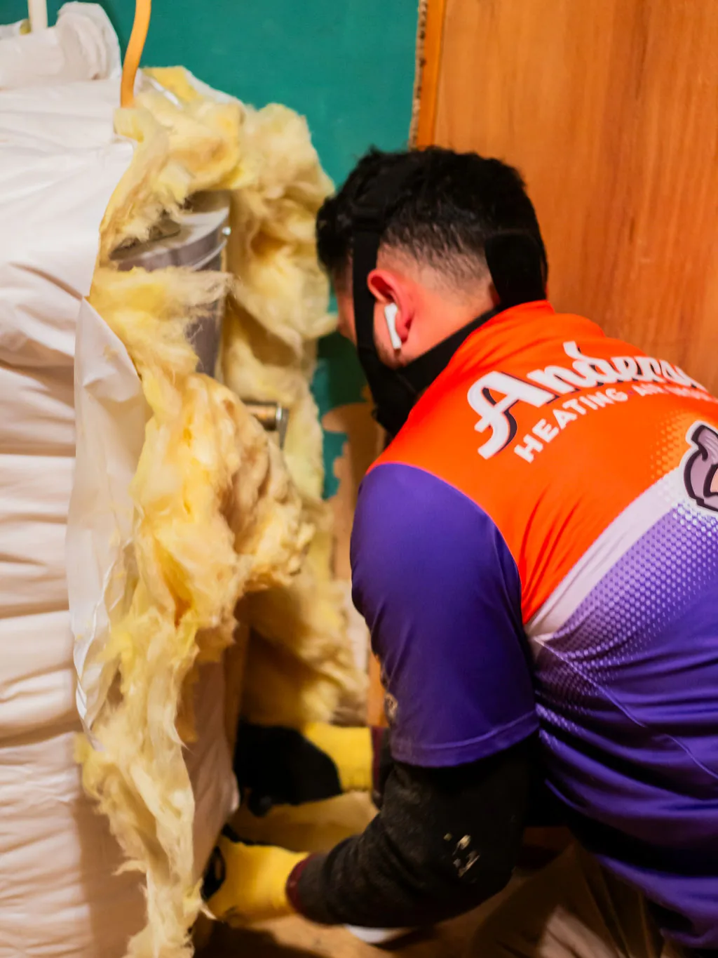 Anderson technician handling fiberglass insulation for an installation