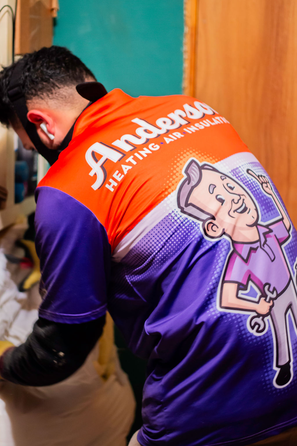 Anderson Heating, Air & Insulation technician at work — branded Anderson Heating, Air & Insulation uniform with John Anderson mascot — Anderson Heating, Air & Insulation serves Ellijay and Gilmer County, GA.