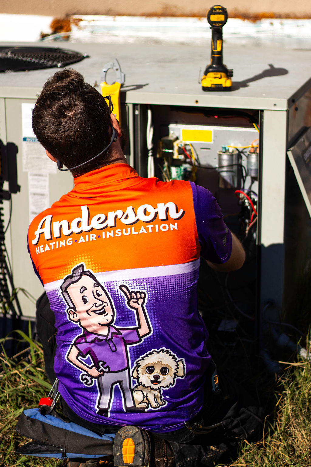 Anderson Heating, Air & Insulation technician working on the wiring and control board inside an outdoor HVAC condenser unit — diagnostic and repair work behind the scenes of every Anderson AC service call.