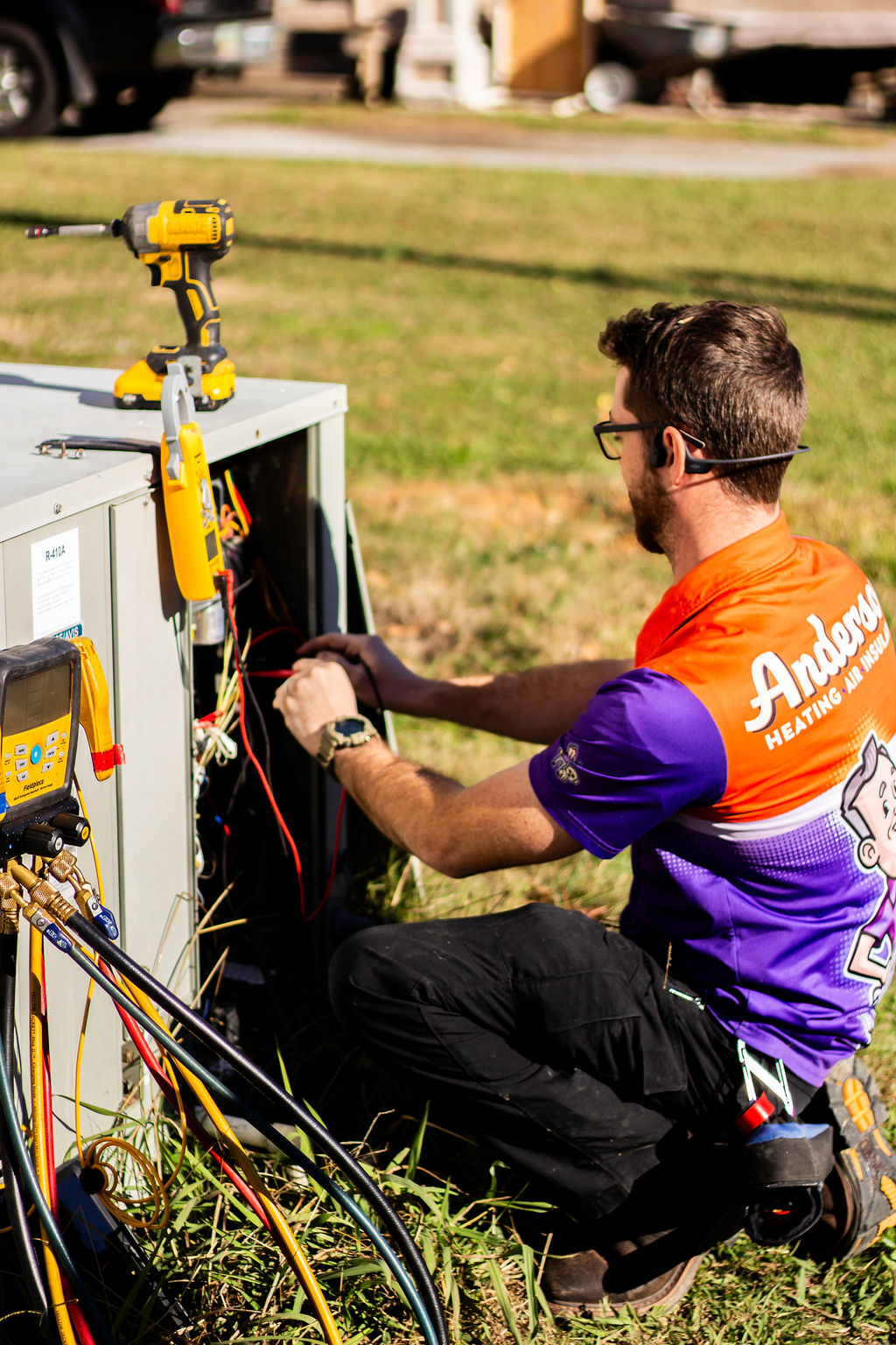 Anderson tech servicing an outdoor AC condenser unit