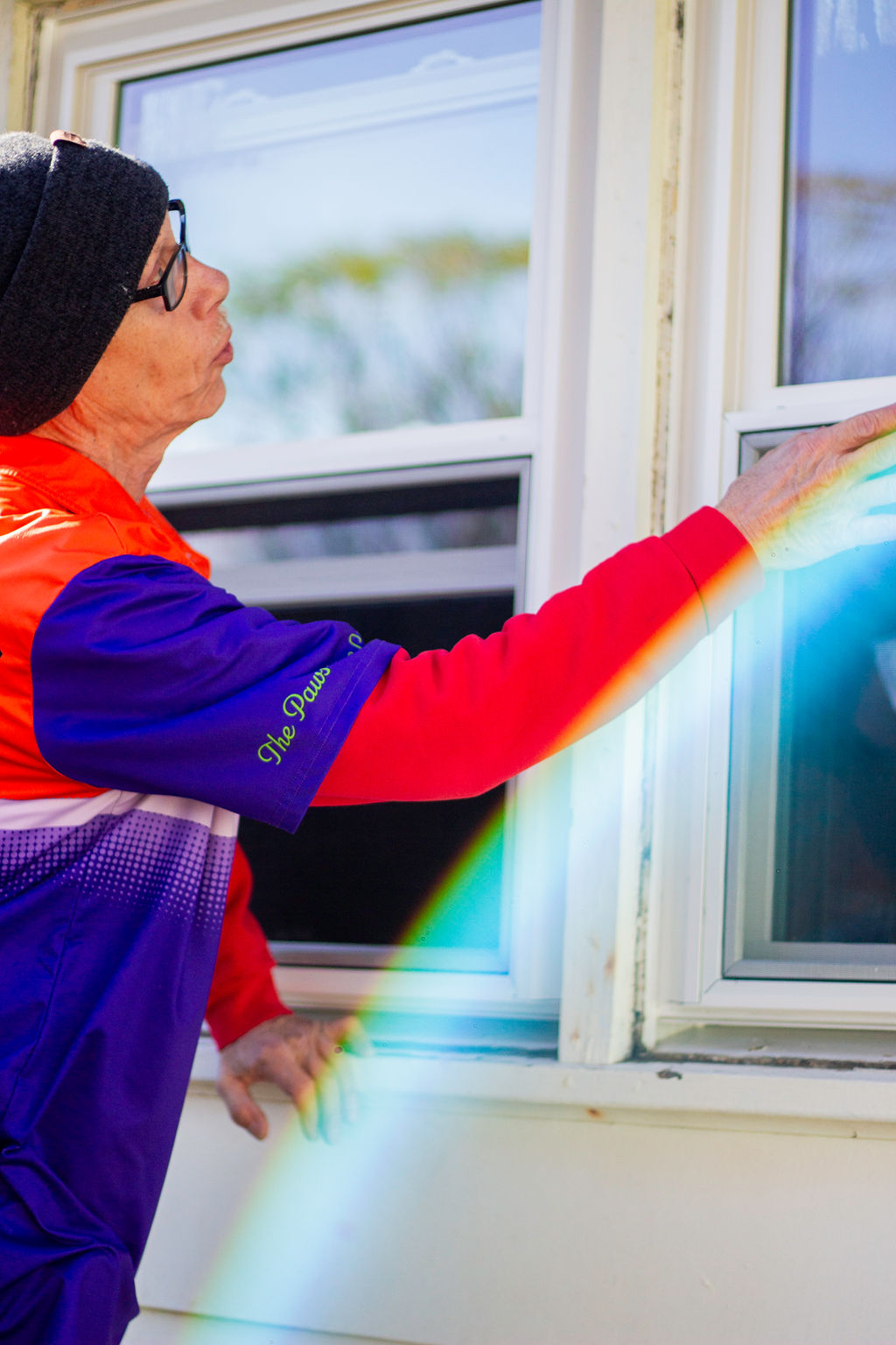 Anderson Heating, Air & Insulation BPI-certified technician inspecting an exterior window for air leakage during weatherization work — part of the company's comprehensive whole-home weatherization, insulation, and rebate-eligible energy upgrades in Northwest Georgia.
