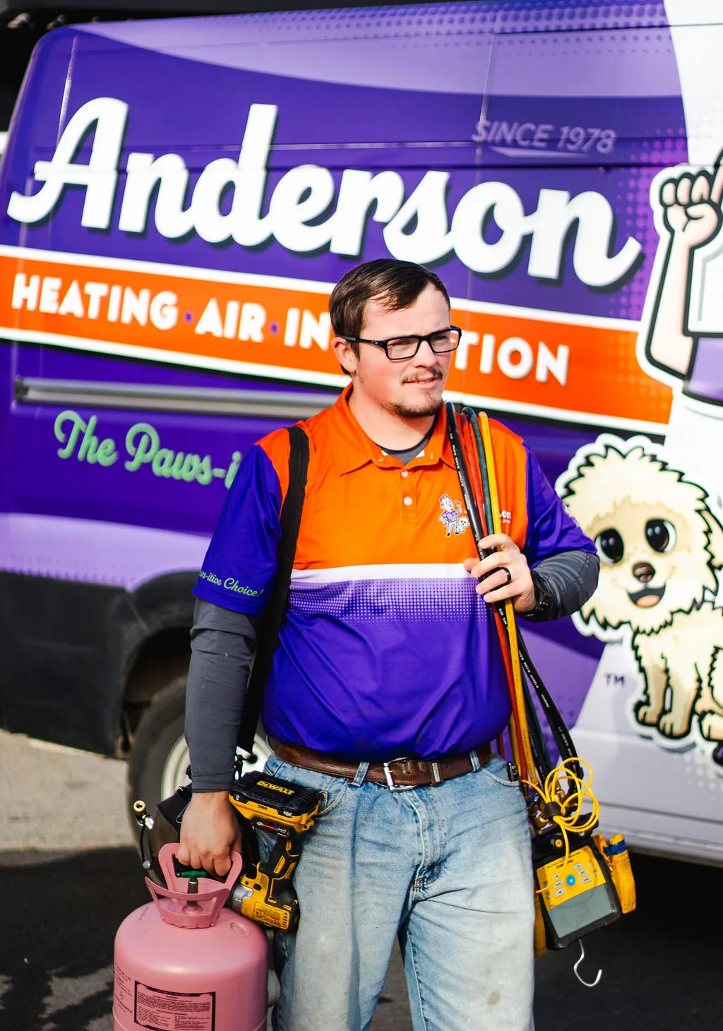 Anderson technician heading out from a service van with gauges and tools