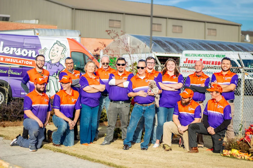 The Anderson team posing together outside the Calhoun shop, with the front row kneeling and John Anderson holding Gypsy at center