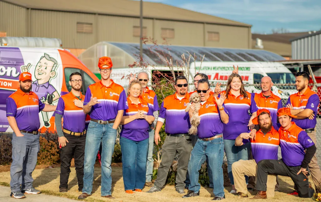 The Anderson crew hamming it up for a playful group photo outside the Calhoun shop — thumbs up, peace signs and bunny ears, with Gypsy at center