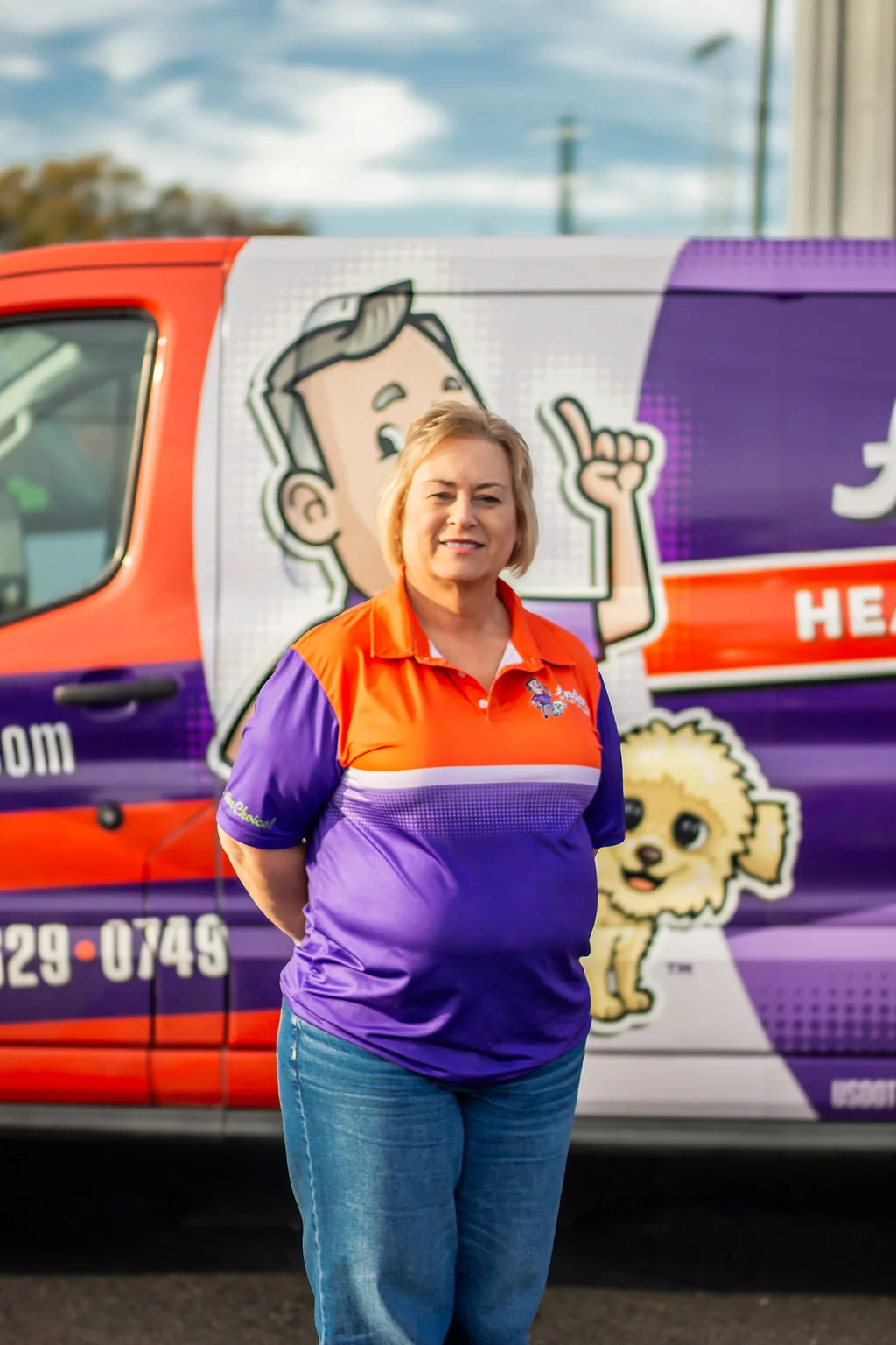 Smiling Anderson team member with short blonde hair in front of a service van