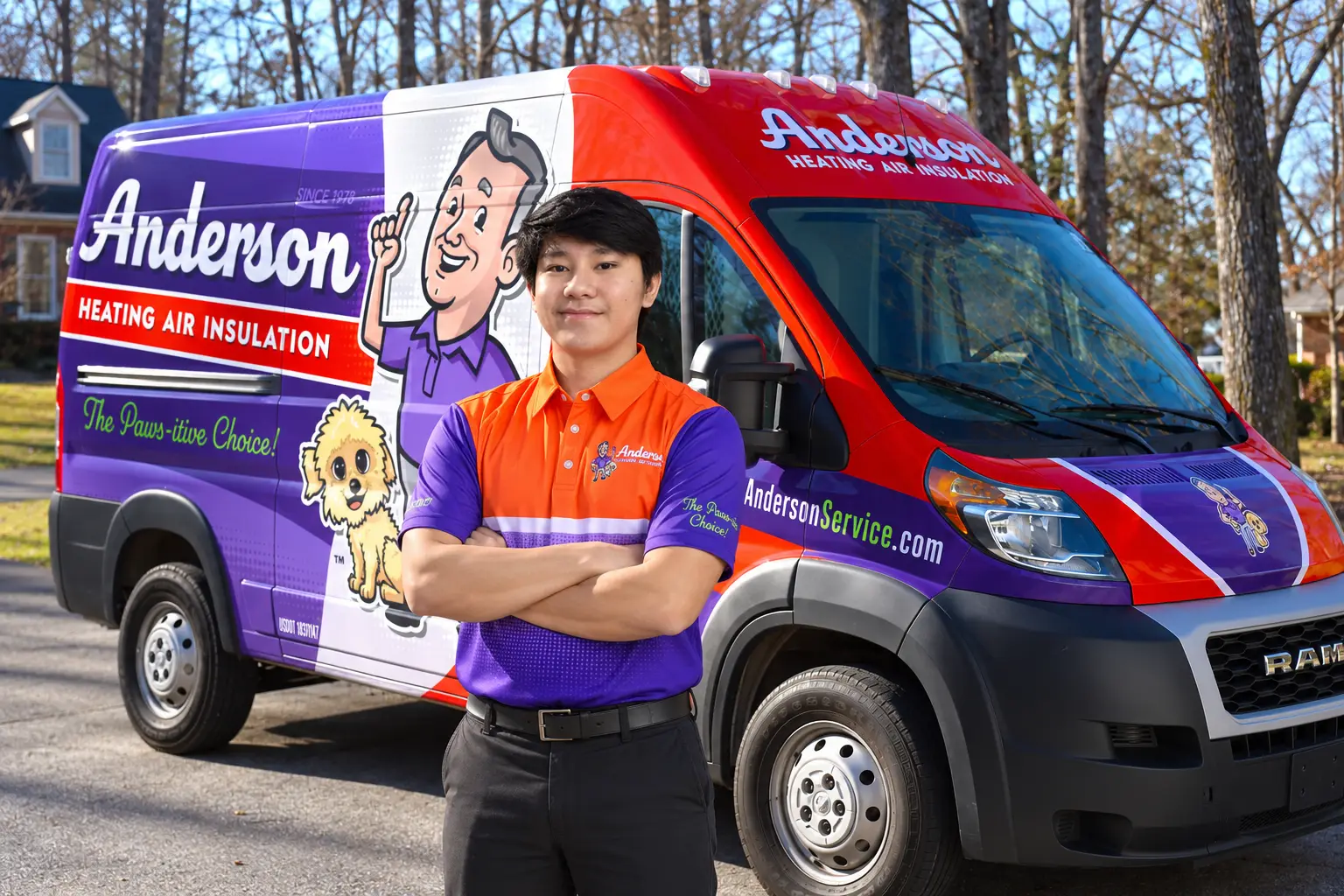 Glenn from the Anderson team standing with arms crossed in front of a wrapped Anderson service van