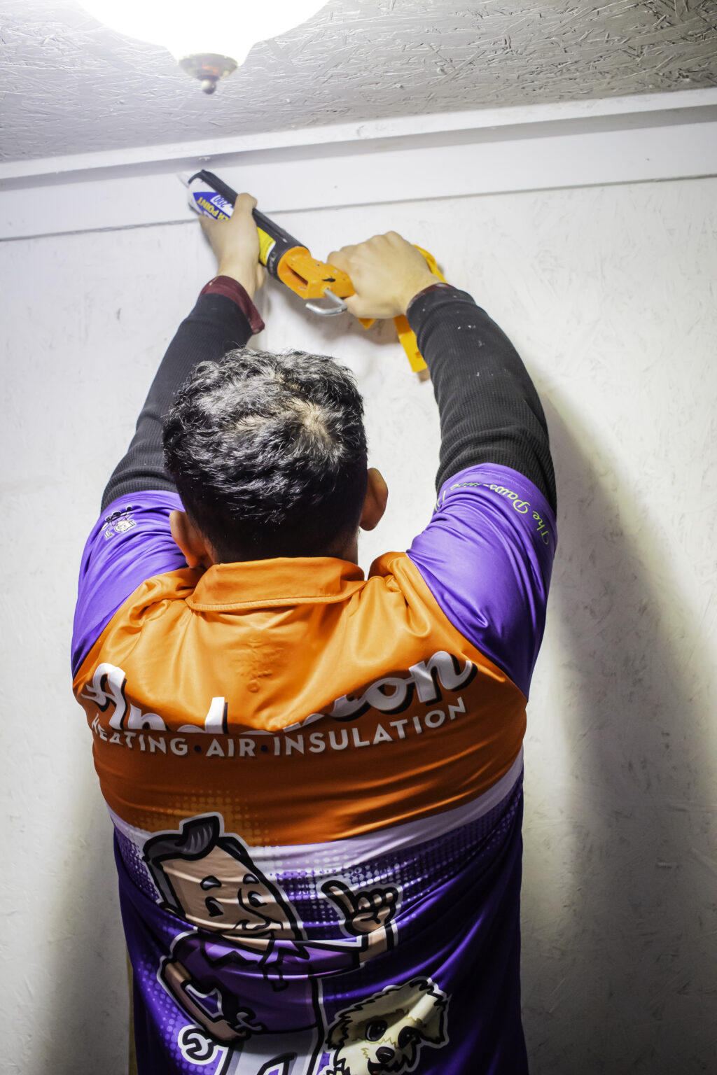 Technician with hands up caulking